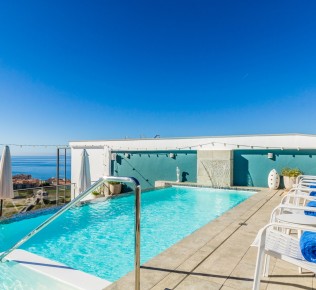 Piscina infinita en la azotea del Hotel Miba: sillas